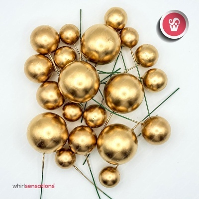 Bolinhas douradas decorativas com hastes verdes sobre fundo branco