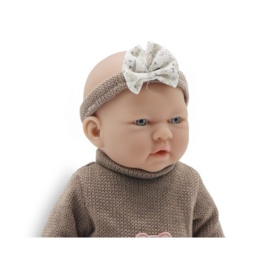 Boneca bebé com camisola castanha de malha e fita de tecido com laço na cabeça