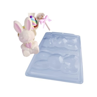 Molde de plástico azul com cavidades de coelho e coelho de pelúcia com pirulito
