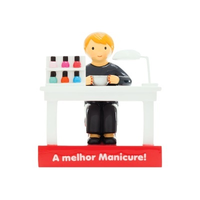Figura decorativa de manicure segurando tigela sentada numa mesa com expositor de vernizes