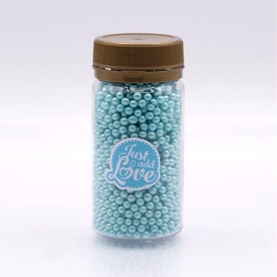 Frasco transparente com pérolas azuis e etiqueta 'Just add Love'