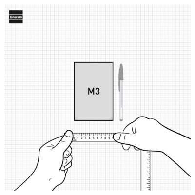 Duas mãos segurando uma régua de 10 cm sobre folha quadriculada, retângulo marcado M3, caneta esferográfica cinzenta e transparente