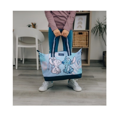 Mala azul com personagens Stitch e Angel e alças azuis escuras em interior doméstico