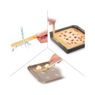 Espátula de silicone amarela com cabo branco a cortar bolo, espalhar creme e ser lavada.