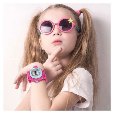 Menina com óculos de sol rosa e relógio de pulso cor de rosa