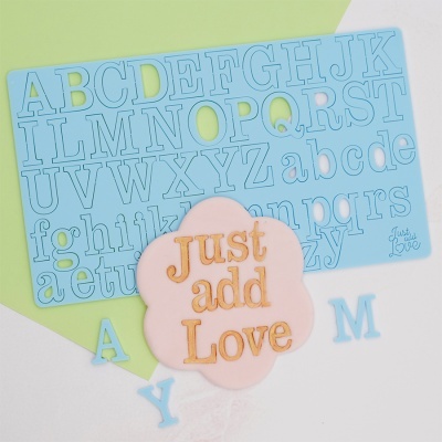 Molde azul de silicone com letras do alfabeto e recorte rosa em forma de flor com texto Just add Love