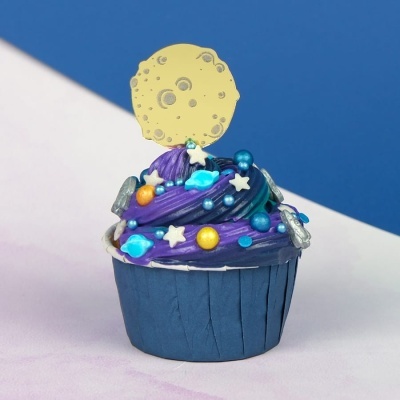 Cupcake decorado com cobertura roxa e azul e topper amarelo em forma de lua