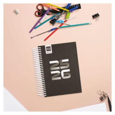 Agenda preta 25 26 com espiral branca e material de escritório colorido ao redor
