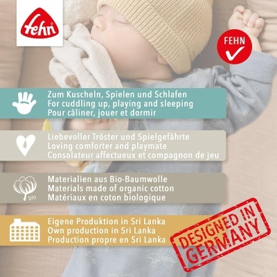 Bebé com gorro bege e pijama cinza-azulado segurando brinquedo claro com texto informativo do produto ao fundo