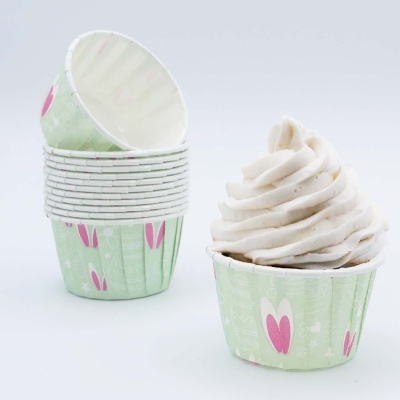 Forminhas para cupcake verdes com corações cor de rosa e chantilly branco