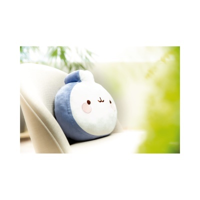 Almofada de peluche azul e branca com rosto sorridente numa cadeira creme