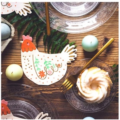 Mesa de madeira com pratos de vidro decorativos e prato em forma de galinha