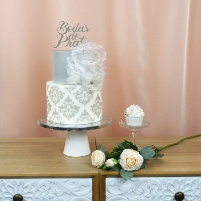 Bolo decorado prata para Bodas de Prata com cupcake e flores creme em móvel de madeira.
