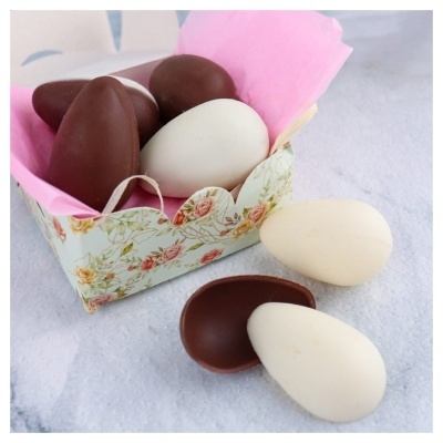 Ovos de chocolate branco e de leite numa caixa floral com forro rosa