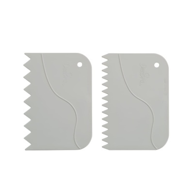 Duas espátulas de plástico branco com bordas serrilhadas e furo para pendurar