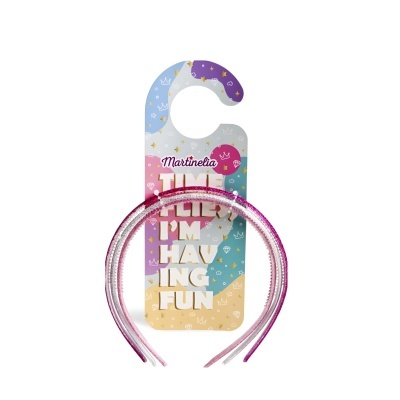 Três tiaras finas brilhantes em rosa, lilás e prata numa embalagem colorida