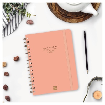 Agenda 2026 cor de salmão com encadernação espiral e lápis ao lado