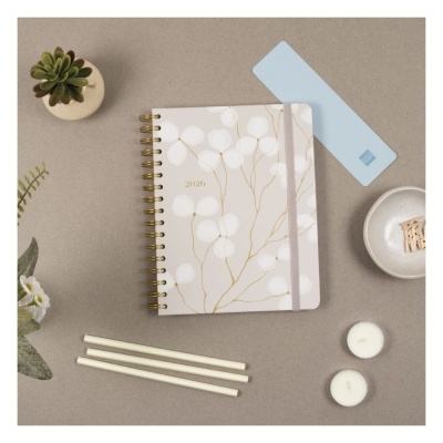 Agenda 2020 capa creme com folhas brancas e douradas, canetas, velas e plantas decorativas