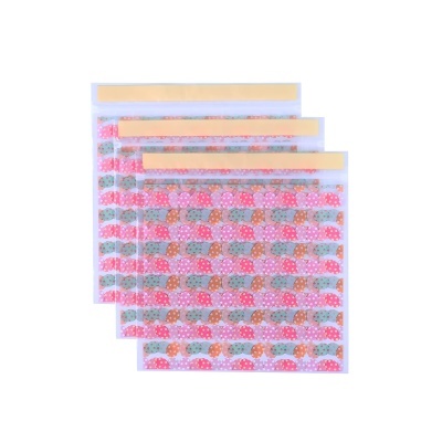 Quatro sacos plásticos transparentes com estampa de cogumelos coloridos e fecho adesivo amarelo