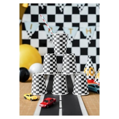 Copo de papel xadrez preto e branco empilhados em pirâmide com carros de brinquedo e decoração de festa em fundo