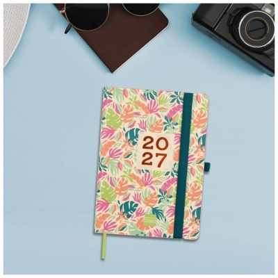 Agenda 2027 com padrão floral, elástico azul e fita amarela sobre fundo azul com acessórios