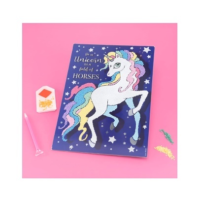 Caderno azul com desenho de unicórnio colorido e texto inspirador