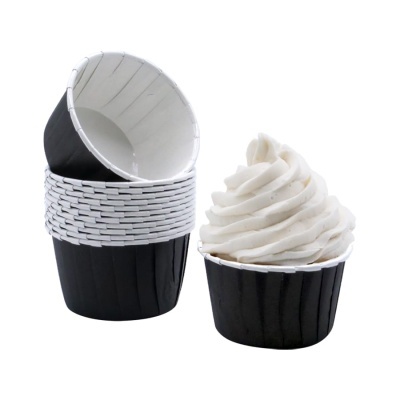 Formas para cupcakes pretas com interior branco, uma com creme branco em espiral