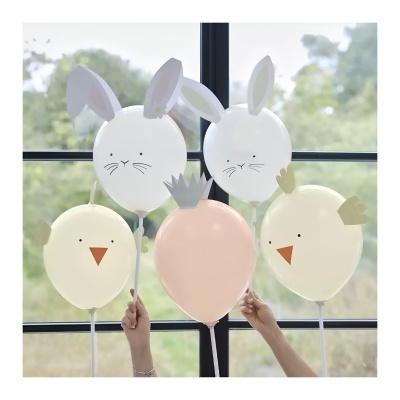 Cinco balões decorativos com tema de coelho e passarinho em tons pastel, sendo dois brancos com orelhas de coelho, dois amarelos com bico e asas de passarinho e um cor de pêssego com coroa cinza.