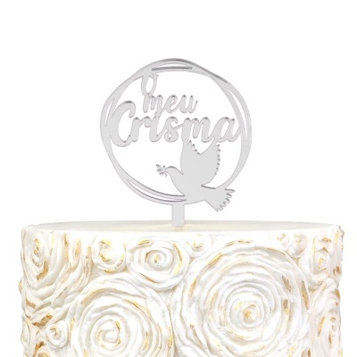 Topo de bolo branco com frase O meu Crisma e pomba, sobre bolo com decoração de rosas brancas e douradas
