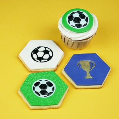 Cupcake e bolachas decoradas com tema de futebol sobre fundo amarelo