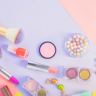 Produtos de maquilhagem coloridos sobre superfície multicolorida.