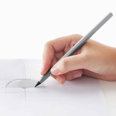 Mão a desenhar com lápis cinzento numa folha de papel branco