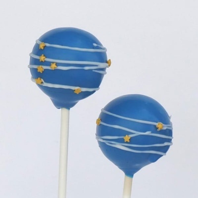 Dois cake pops azuis decorados com estrelas amarelas e linhas brancas.