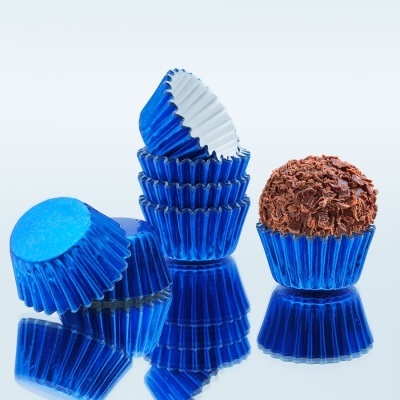 Brigadeiro em forminha azul metálica com várias forminhas azuis empilhadas