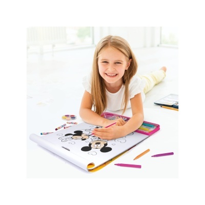 Criança a colorir livro da Disney com lápis de cor no chão interior