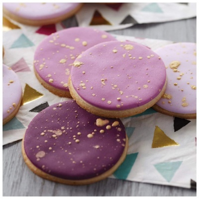 Biscoitos decorados com glacê roxo e lilás com salpicos dourados