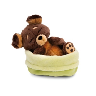Urso de peluche castanho e bege numa cama verde clara