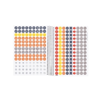 Caderno aberto com autocolantes redondos coloridos e vários símbolos