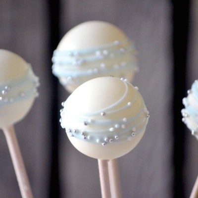 Bolachas em forma de bola com chocolate branco e decorações prateadas e azuis