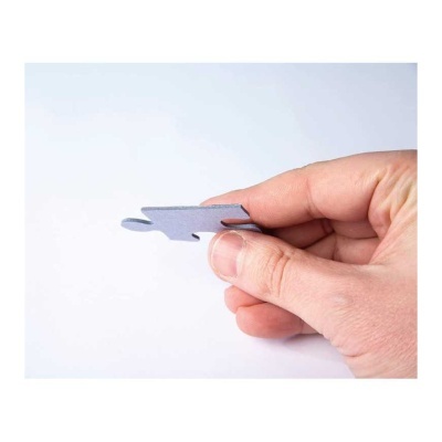 Peça cinzenta de puzzle sendo segurada por uma mão