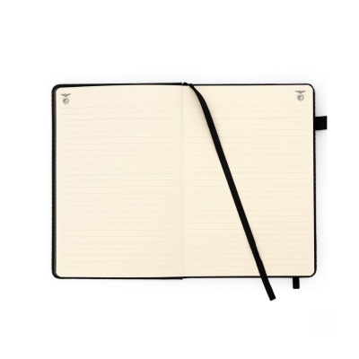 Caderno aberto com páginas pautadas e fita marcador preta