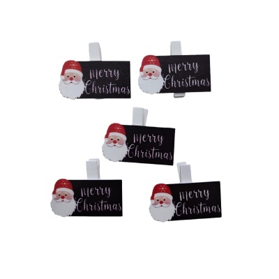 Pregadeiras de madeira com placa preta Merry Christmas e rosto de Pai Natal.