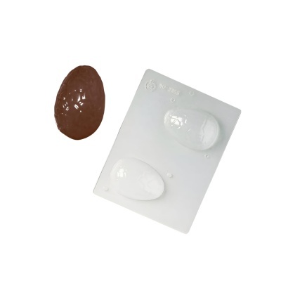Molde de plástico branco com cavidades de ovo e ovo de chocolate castanho