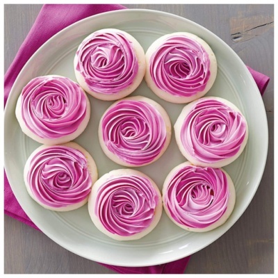 Bolachas decoradas com glacê rosa em prato branco