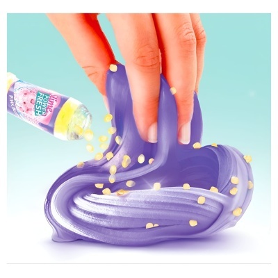 Mão a mexer slime roxo com partículas amarelas e frasco a despejar partículas