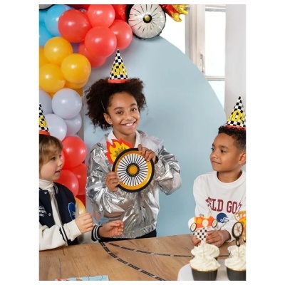 Crianças em festa com chapéus decorativos, balões coloridos e cupcakes numa mesa