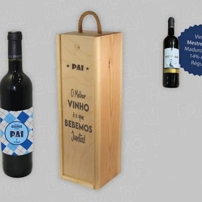 Garrafa de vinho tinto com rótulo azul e branco e caixa de vinho de madeira com texto gravado