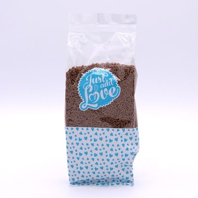 Saco transparente com confetis de chocolate e etiqueta azul e branca.