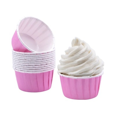 Forminhas cor-de-rosa para cupcakes com uma decorada com chantilly branco