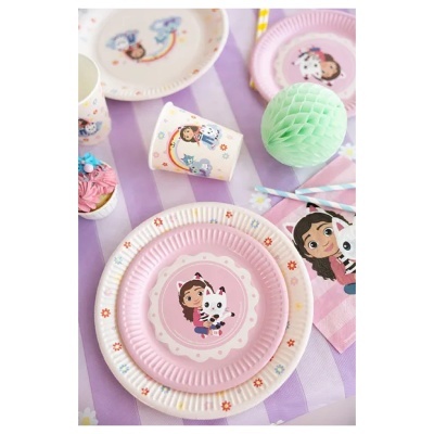 Conjunto de festa infantil com pratos, copos, guardanapos e palhinhas com desenhos de menina e gato, cupcake decorado e bola verde clara sobre toalha lilás.